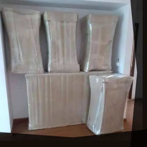 Multiple large, rectangular boxes wrapped in brown packing material.